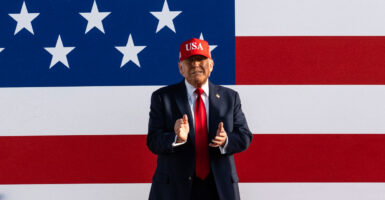 President Donald Trump with a giant American flag as backdrop