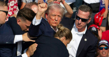 President Donald Trump raises his fist defiantly after being shot.