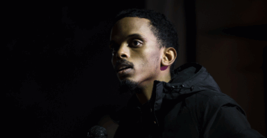 Omar Fateh in a dark coat speaks into a microphone in Minneapolis, Minnesota.