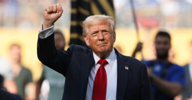 President Donald Trump raises his right hand in a fist.