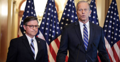Mike Johnson and John Thune stand at a lectern at the Capitol.