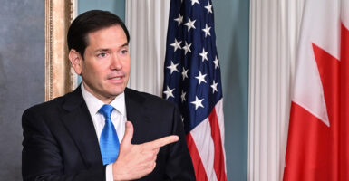 Secretary of State Marco Rubio with an American flag as backdrop