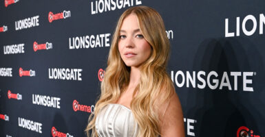 Sydney Sweeney stands on the red carpet and looks to her left.