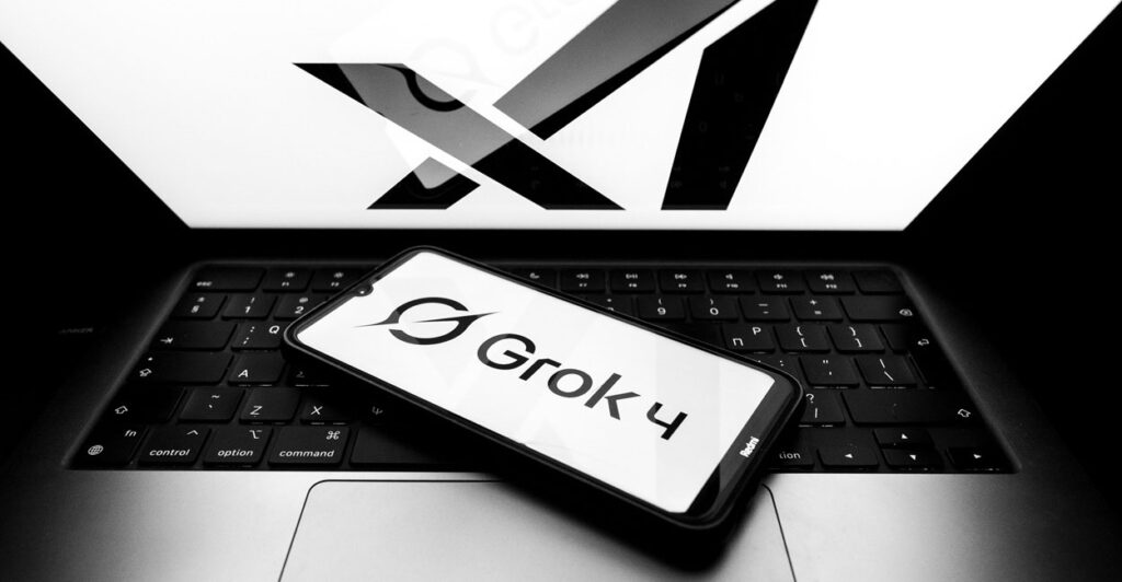 A cell phone lays on the top of a laptop computer's keyboard.