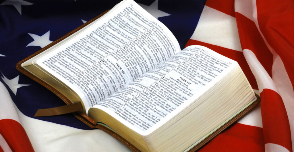 An opened Bible rests atop a U.S. flag