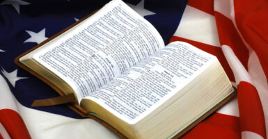 An opened Bible rests atop a U.S. flag