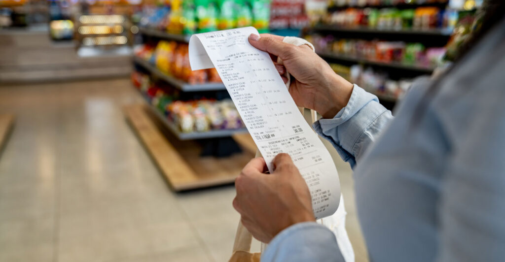 A supermarket shopper examines her cash register receipt.