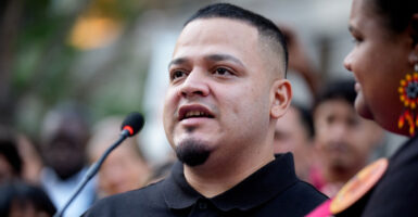 Kilmar Abrego Garcia stands outdoors at a press conference and speaks with a microphone in front of him.