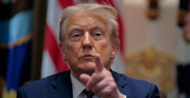 Donald Trump points with his left hand at a reporter during a press conference.