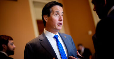 Sen. Bernie Moreno in a blue suit and tie talks to reporters.