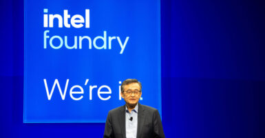 Intel CEO Lip-Bu Tan stands in front of an Intel sign.