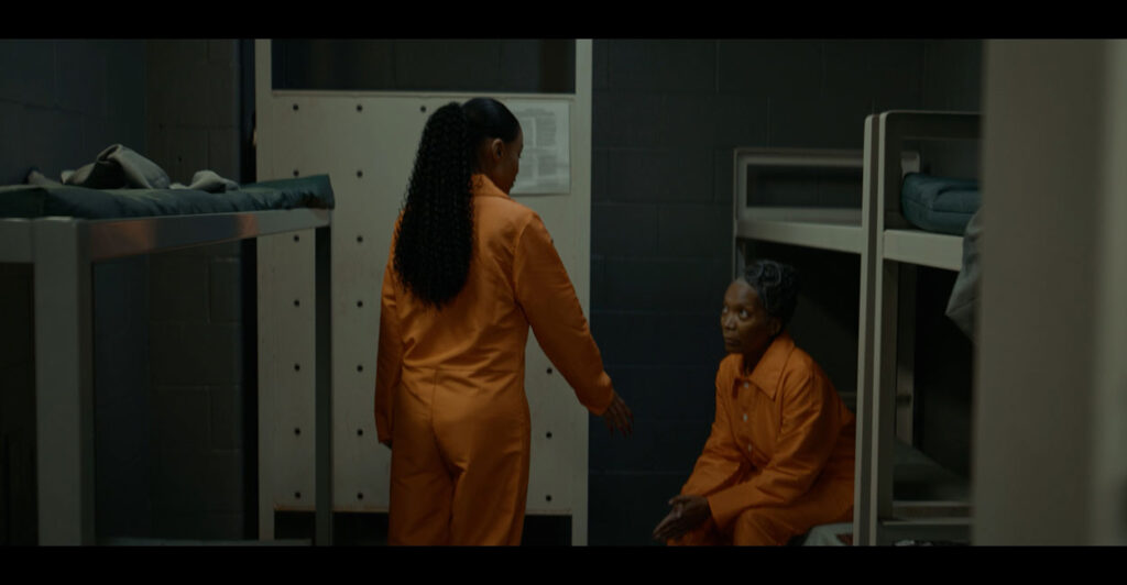 Beverlyn B. Williams, standing, offers her hand to a fellow inmate in orange in a scene from "Pardon Me."