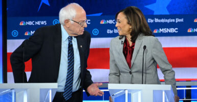 Then-Democratic presidential hopefuls Sens. Bernie Sanders, I-Vt., and then-Sen. Kamala Harris, D-Calif., chat during a Democratic presidential primary debate in Atlanta on Nov. 20, 2019.