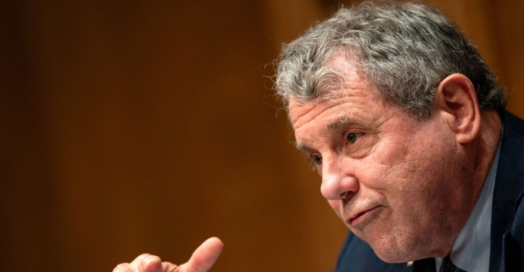 Former Sen. Sherrod Brown gestures as he speaks during a committee hearing.