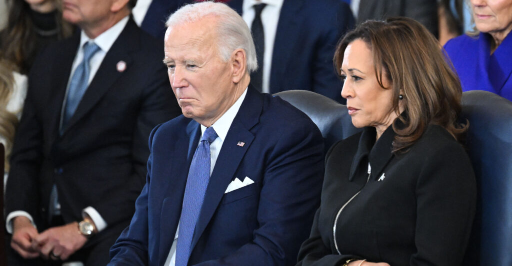 Joe Biden in a dark suit sitting next to Kamala Harris in a black jacket