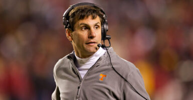 Former college football coach Derek Dooley on the field and wearing a headset