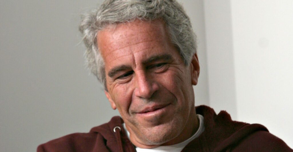 Jeffrey Epstein looking down with a hooded sweatshirt on