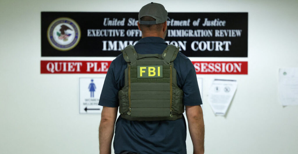 An FBI agent stands with his back turned.