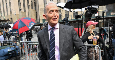 Trey Gowdy walks outside Manhattan Criminal Courthouse holding some documents.