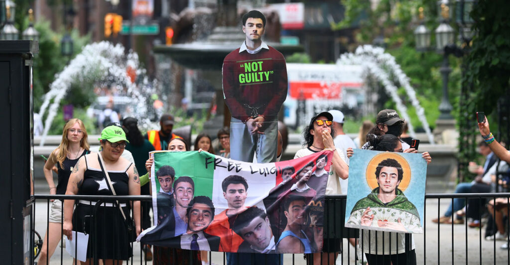 Protesters holding photos of Luigi Mangione.