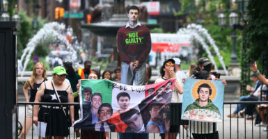Protesters holding photos of Luigi Mangione.