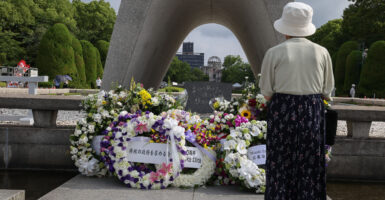 A visitor prays after offering flowers in front of the cenotaph ahead of the 80th anniversary of the atomic bomb dropped on Hiroshima at the Hiroshima Peace Memorial park on August 05, 2025 in Hiroshima, Japan.