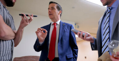 Sen. Bernie Moreno gestures as he speaks to reporters.