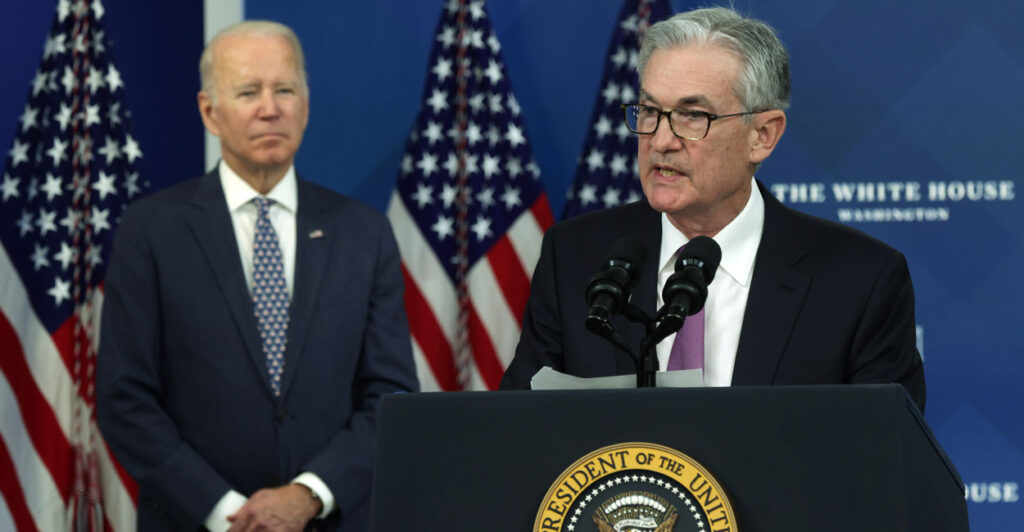 Then-Federal Reserve Board Chairman Jerome Powell speaks at the presidential podium with then-President Joe Biden Standing behind him