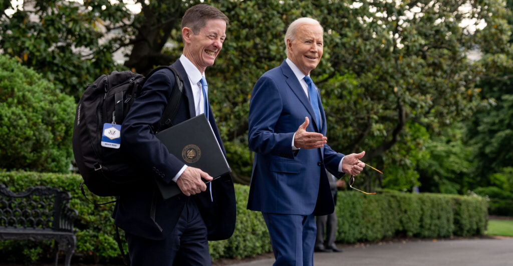 President Joe Biden walks with top aide Bruce Reed outside the White House.