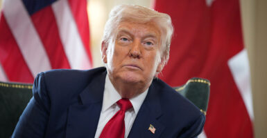 Donald Trump looks in a blue suit with a red tie