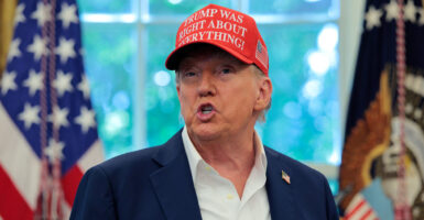 President Donald Trump, wearing a hat and no tie, speaks in the Oval Office. (Chip Somodevilla/Getty Images)