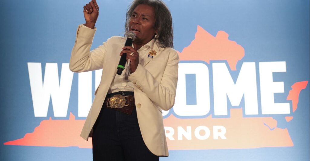 Winsome Earle-Sears stands in front of a campaign ad.