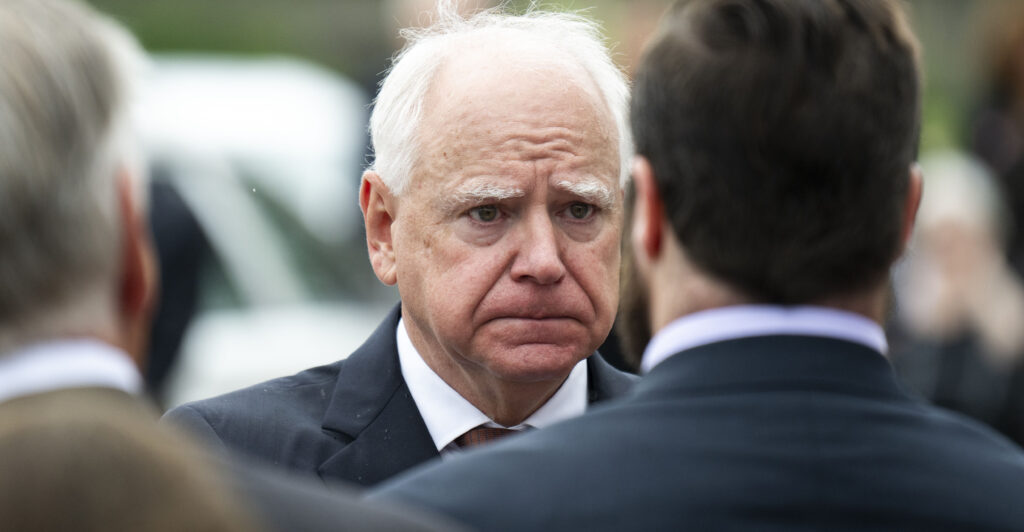 Minnesota Gov. Tim Walz presents a Minnesota flag to the family of DFL Rep. Melissa Hortman and her husband Mark Hortman.