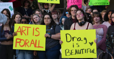 Attendees hold signs during a protest sponsored by Texas A&M University Queer Empowerment Council's Day of Drag protest on campus in College Station.