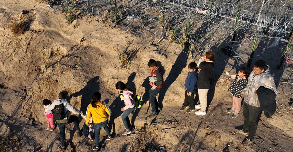 Illegal immigrant children walk next to razor wire after crossing the Rio Grande in Eagle Pass, Texas, in February.