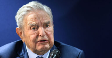 George Soros and a blue suit with a frown on his face
