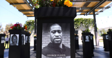 A large photo of George Floyd is on a podium that has flowers on top.
