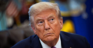 Donald Trump sits and looks to his left after signing an executive order.