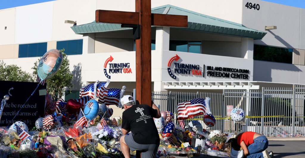 Dan Beazley and Natalia Hernandez pray at the makeshift memorial for Charlie Kirk outside of the headquarters of Turning Point USA on Tuesday in Phoenix, Arizona.