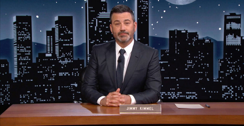 Jimmy Kimmel behind his now-suspended TV show's on-set desk with his nameplate on it