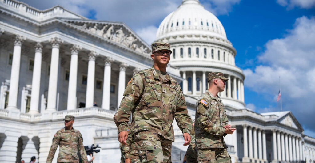 A member of the National Guard walks with fellow guardsmen by the U.S. Capitol building.