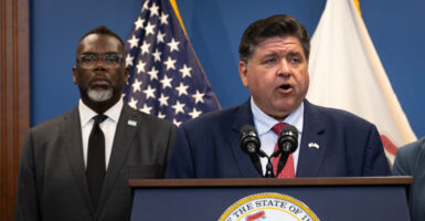 Illinois Gov. JB Pritzker speaks to the press as Chicago Mayor Brandon Johnson listens.