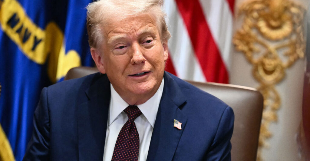 President Donald Trump with a U.S. flag as a backdrop