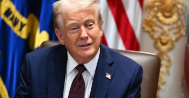 President Donald Trump with a U.S. flag as a backdrop