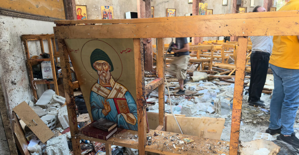 Rescue workers and civilians on June 22 inspect the aftermath of a suicide bombing at St. Elias Greek Orthodox Church in Damascus, Syria.