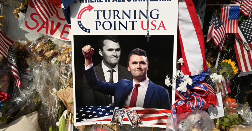 Turning Point USA display including photo with a color and black-and-white photo of Charlie Kirk.