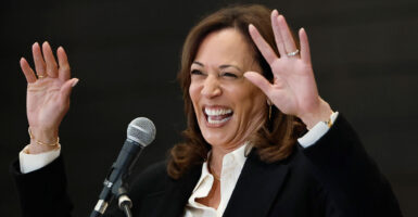 A close-up of a laughing Kamala Harris with her hands up.