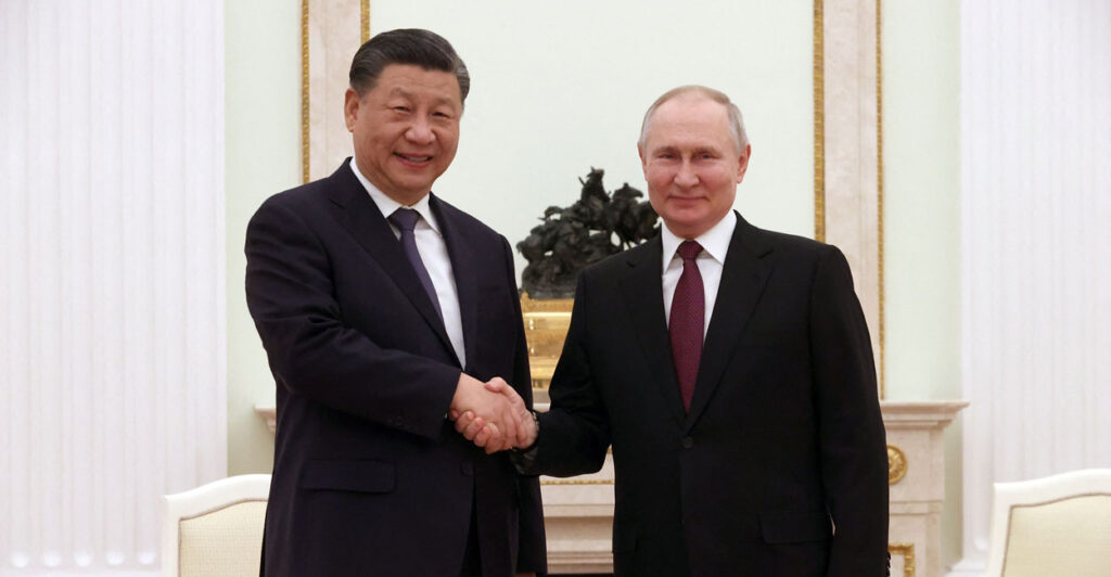 Chinese leader Xi Jinping shakes hands with Russian leader Vladimir Putin.