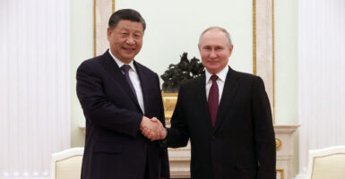 Chinese leader Xi Jinping shakes hands with Russian leader Vladimir Putin.