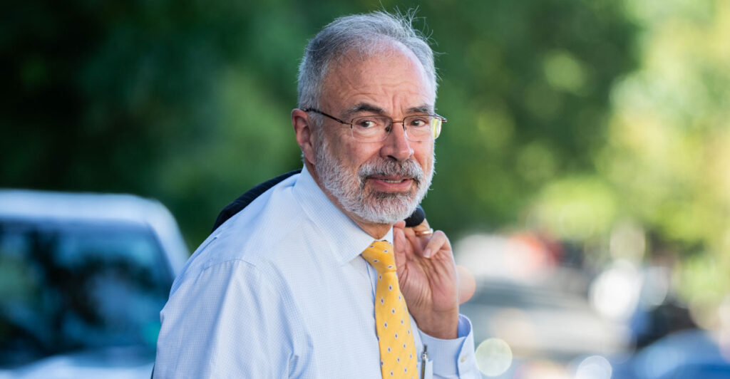 Freedom Caucus Chairman Andy Harris, with his jacket draped over his shoulder, walks outside the United States Capitol.